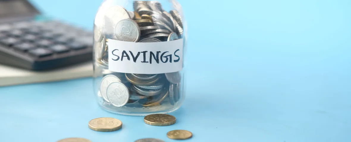 Savings jar of coins with calculator representing extra concessional super contributions under the $32,500 cap
