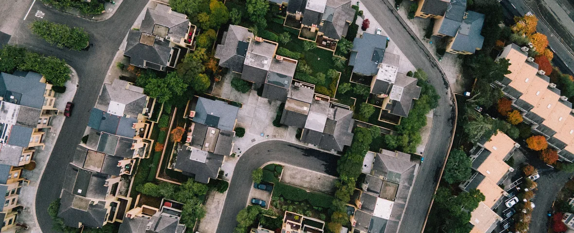 Aerial view of curving suburban streets lined with houses and trees